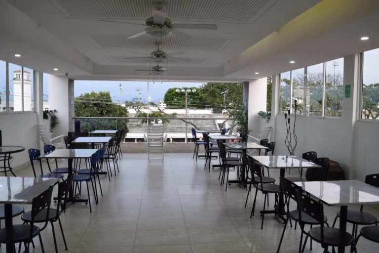 Restaurante terraza del Hotel Travelers Sport con mesas, sillas y vistas panorámicas a la ciudad