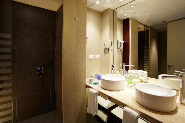 Baño moderno con doble lavabo y zona de ducha en el hotel Enjoy Punta del Este
