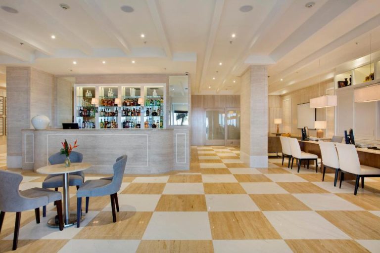Bar y lobby elegante del Windsor California Copacabana con suelo a cuadros y amplia barra de bebidas