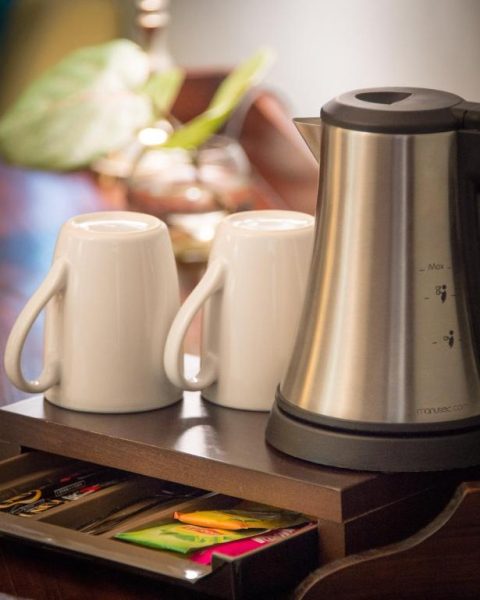 Tetera eléctrica y tazas de café con surtido de tés en la habitación del Hotel l'Impératrice