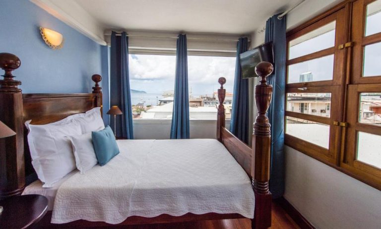 Habitación doble con cama de madera y vista al mar en Hotel l'Impératrice