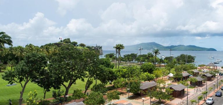 Vista panorámica de la bahía de Fort-de-France desde el Hotel l'Impératrice con el Fort Saint-Louis y palmeras