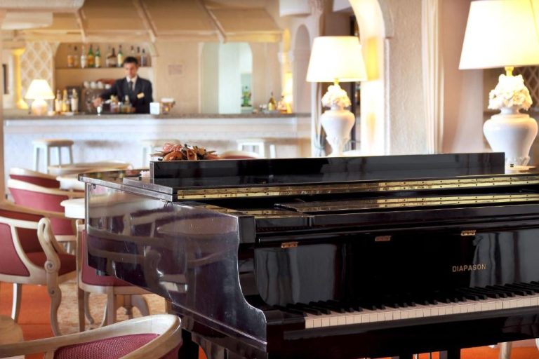 Piano de cola Diapason en el elegante bar del Grand Hotel Smeraldo Beach con iluminación cálida
