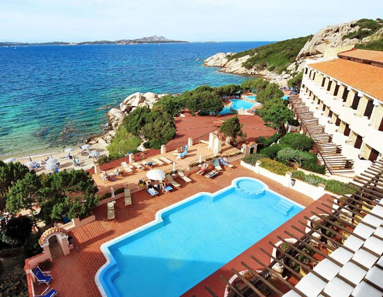 Vista aérea de la piscina exterior y playa del Grand Hotel Smeraldo Beach en Cerdeña