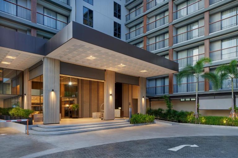 Entrada principal iluminada del Park Nine Hotel Suvarnabhumi con porche moderno y jardines tropicales en Bangkok
