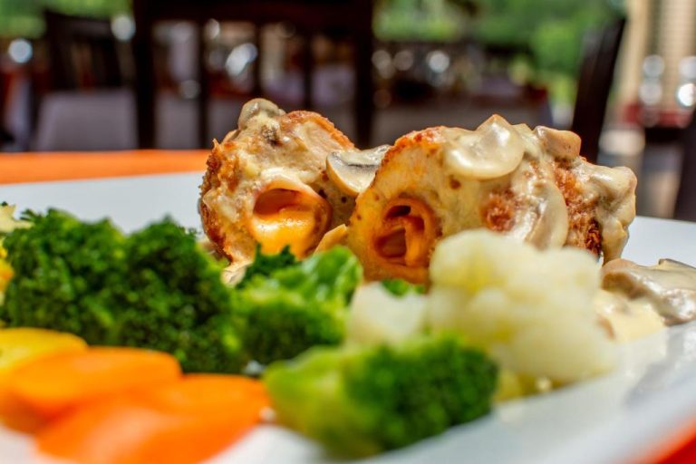 Plato de pollo relleno con salsa de champiñones y verduras al vapor en el restaurante del Hotel Pacuare