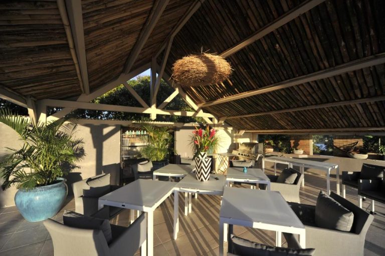 Terraza exterior con techo de palapa y mobiliario lounge en The Bahi Villa Adults Only
