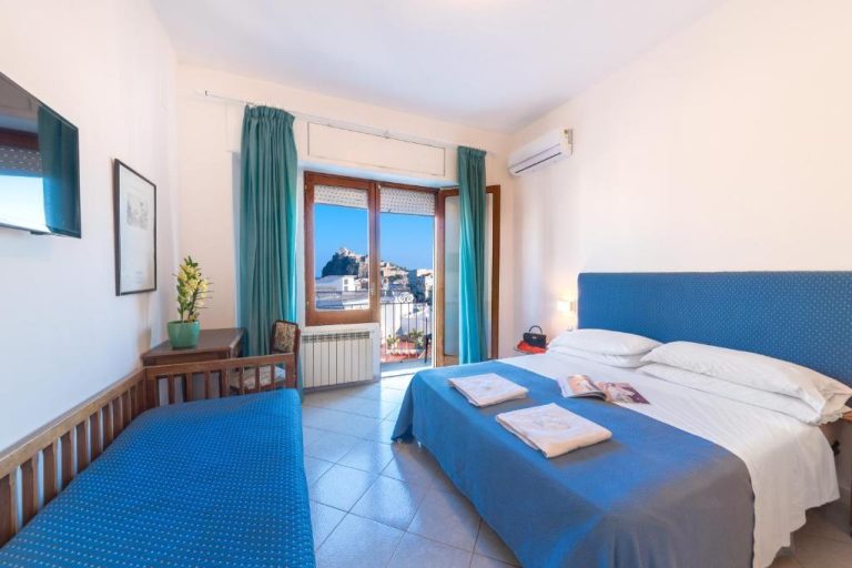Habitación doble con cama azul y vistas al castillo en Hotel Europa, amplia y luminosa