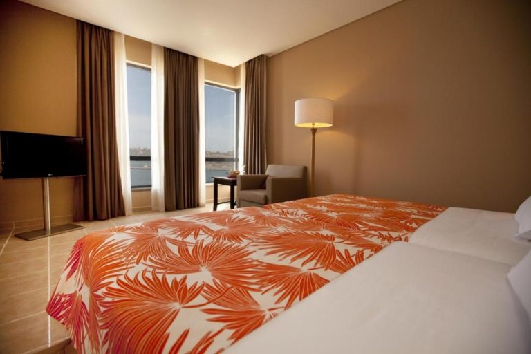 Habitación doble con colcha tropical y vistas al mar en el Hotel Pestana Trópico