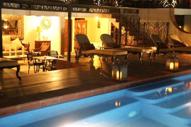 Piscina iluminada con terraza y zona lounge nocturna en La Pasion Colonial Hotel Boutique By Bunik