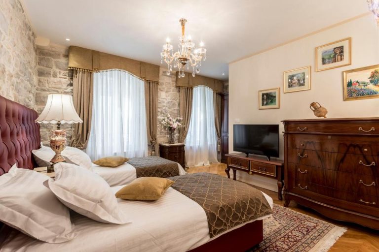 Habitación doble de estilo clásico con camas twin y muebles de madera en Villa Nepos Hotel