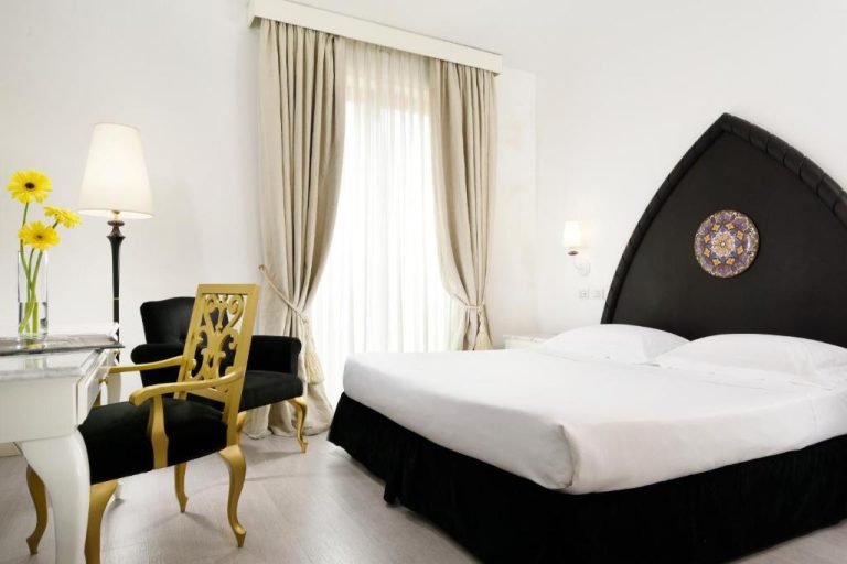 Habitación doble de lujo con cabecero negro y decoración clásica en Palace Catania UNA Esperienze