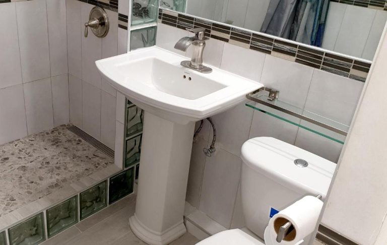 Baño moderno con lavabo de pedestal y ducha de obra en Beach One Bedroom Suite A17