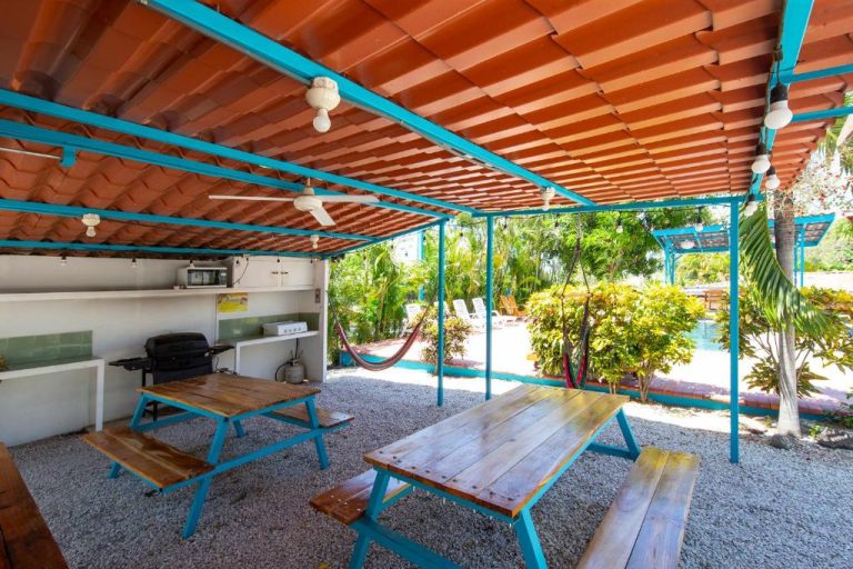 Área de barbacoa y mesas de picnic bajo pérgola con vistas al jardín en Hotel Diversion Tropical