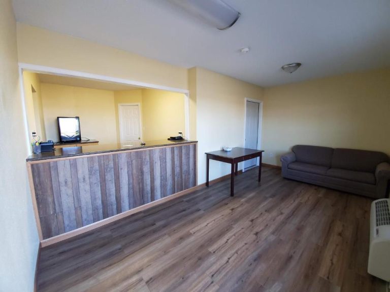 Recepción con mostrador de madera y sala de espera con sofá en el Cuba Inn