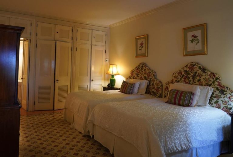 Habitación doble con cabeceros florales y camas gemelas en el histórico Graycliff Hotel de Nassau