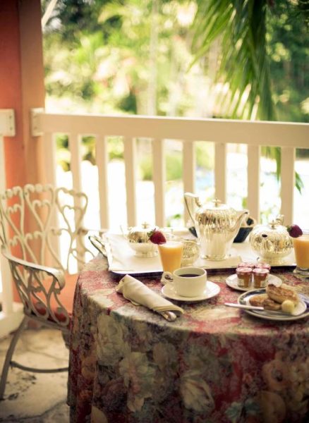 Desayuno elegante en terraza exterior del Graycliff Hotel con vajilla de plata y vistas al jardín tropical