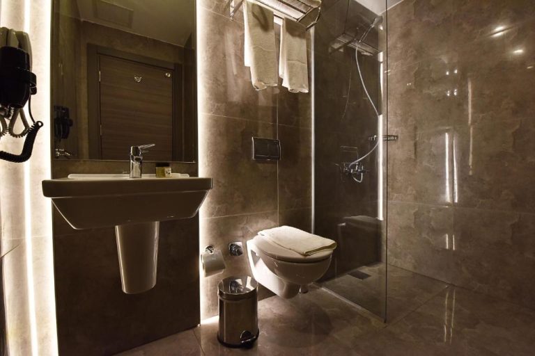 Baño moderno con ducha de cristal y revestimiento de mármol en el Parkim Ayaz Hotel