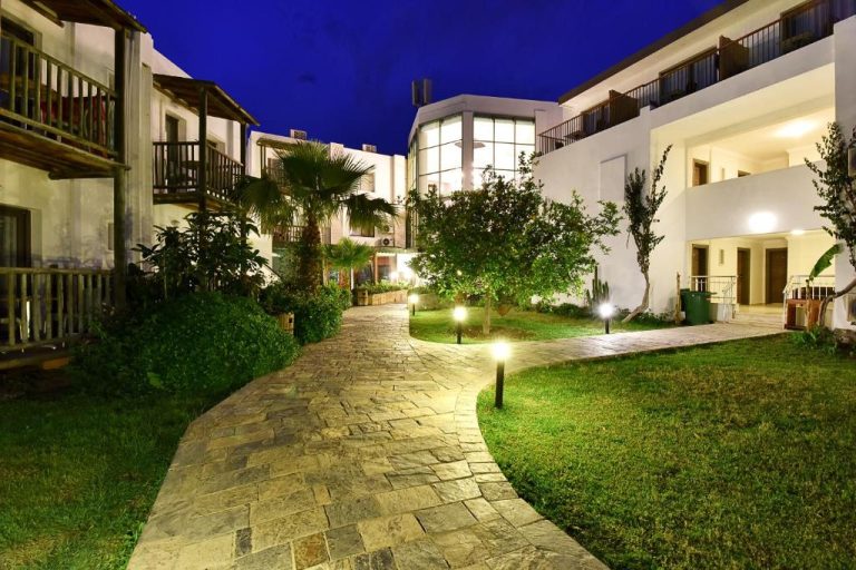 Jardín iluminado con sendero de piedra del Parkim Ayaz Hotel durante la noche