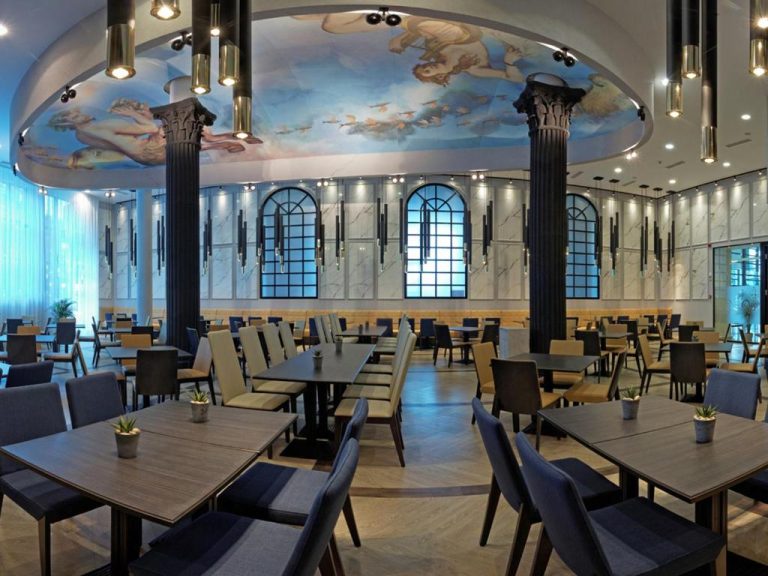 Elegante restaurante del Astera Hotel & Spa con frescos en el techo, columnas clásicas y amplio comedor