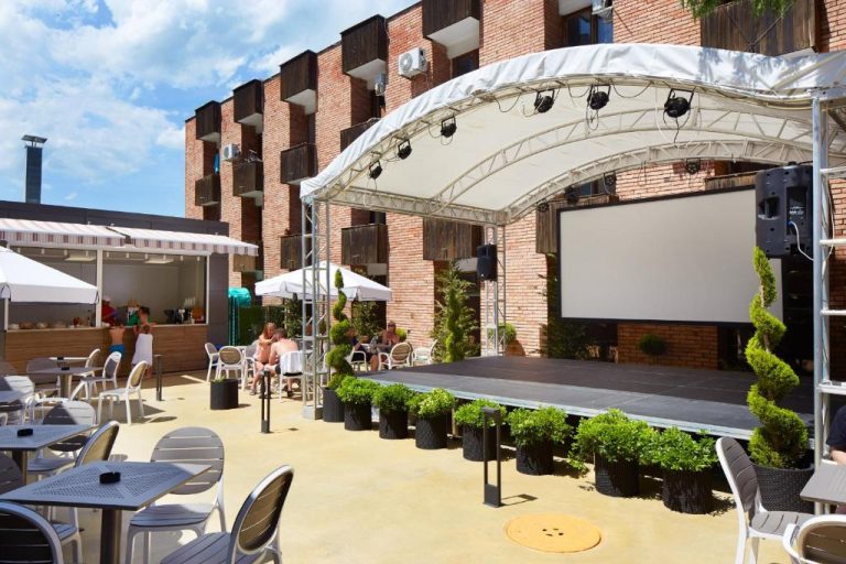 Escenario al aire libre con pantalla de proyección y zona de bar en Diamond Hotel Sunny Beach All Inclusive