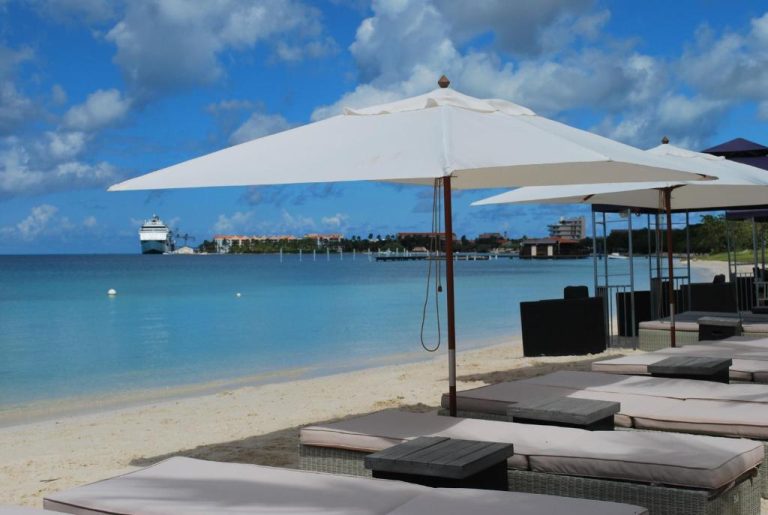 Tumbonas y sombrillas en la playa del voco Surfside Aruba by IHG con vistas al mar Caribe