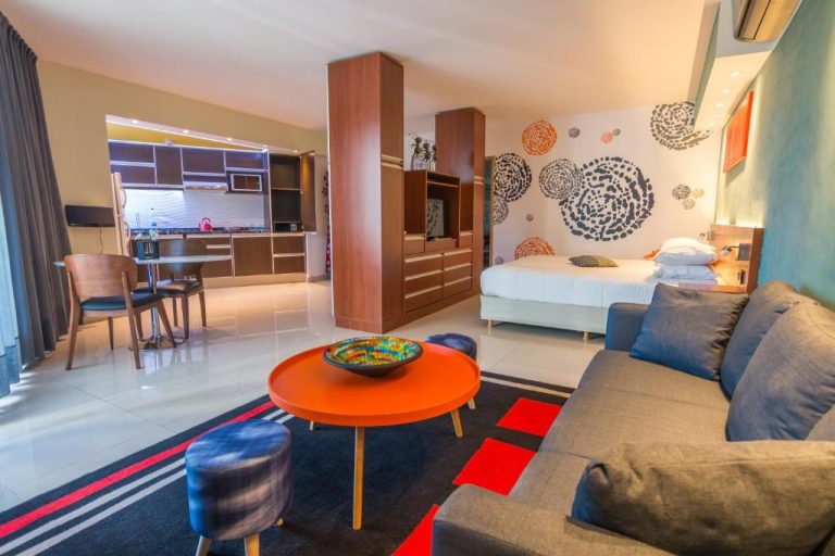 Suite moderna con sala de estar, cocina equipada y cama en Shoshana Hotel Boutique