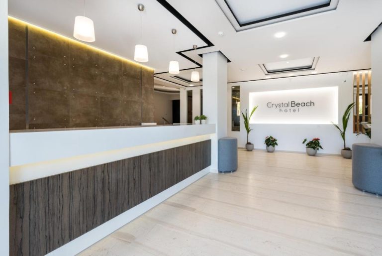 Recepción moderna y luminosa del Crystal Beach Hotel con mostrador de mármol y decoración minimalista
