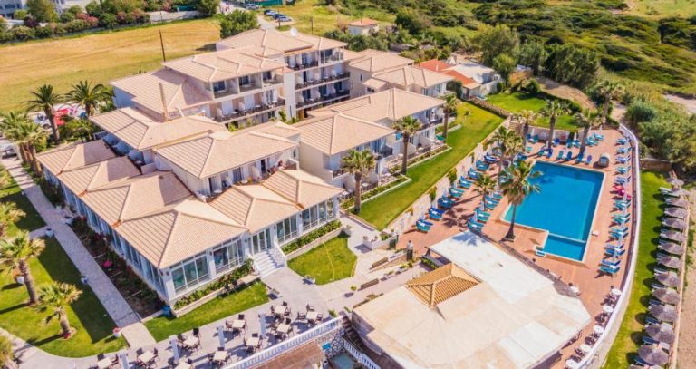 Vista aérea del Crystal Beach Hotel con piscina exterior, tumbonas y jardines tropicales