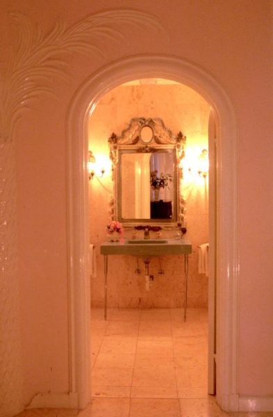 Elegante baño de lujo con espejo dorado vintage y lavabo de mármol en el Graycliff Hotel
