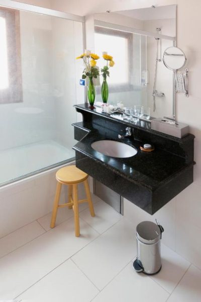 Baño moderno con encimera de granito negro y bañera del Hotel Westfalenhaus