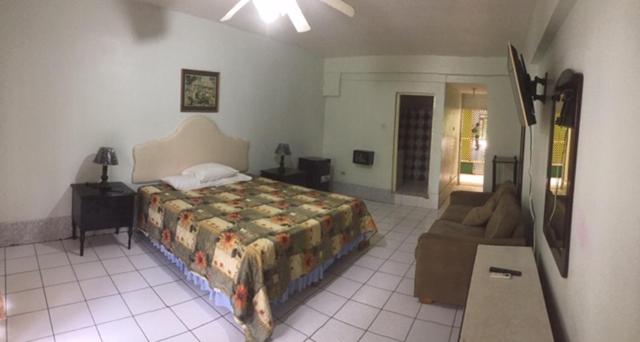 Habitación doble amplia con cama matrimonial y sofá en Negril Beach Club Condos Jamaica