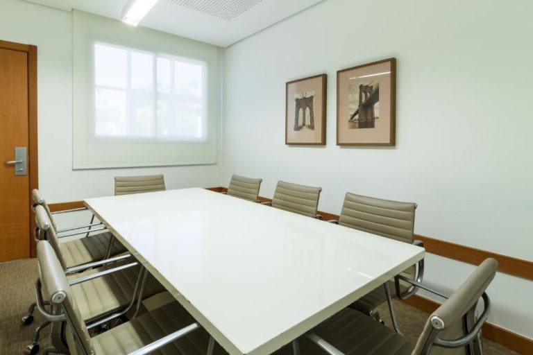 Sala de reuniones con mesa blanca y sillas ejecutivas en Boulevard Residencial