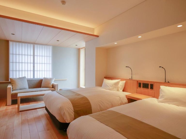 Habitación twin con diseño japonés minimalista y suelos de madera en Kaminarimon Ryokan