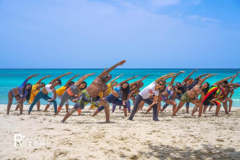 Clase de yoga grupal en la playa de Yoga Dreams Negril con vistas al mar turquesa de Jamaica