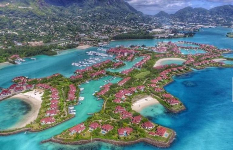 Vista aérea de Eden Island con apartamentos frente al mar, marina y aguas turquesas en Seychelles