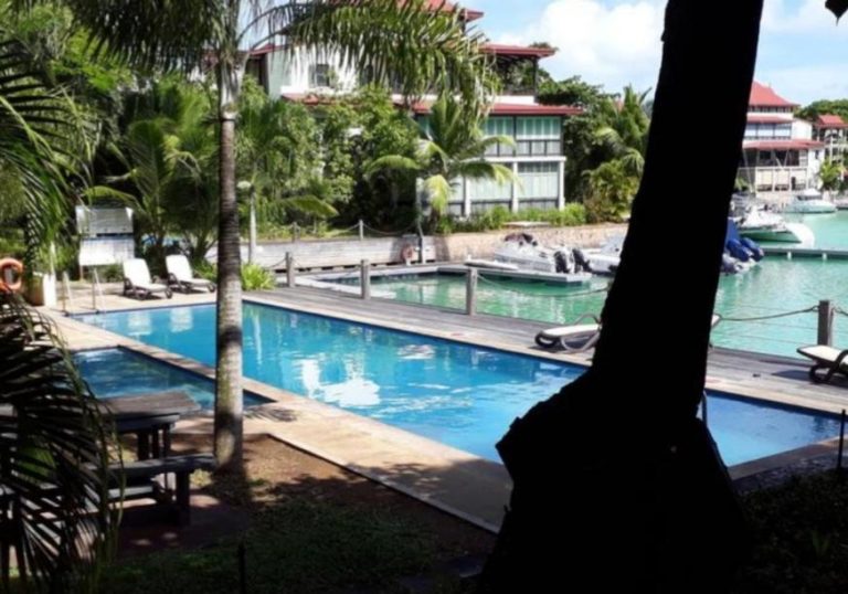Piscina exterior con vistas a la marina y embarcaciones en Eden Island Self Catering Apartment, Seychelles