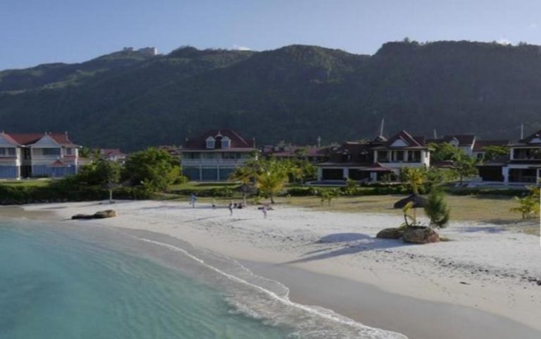 Villas frente a la playa de arena blanca en Eden Island Self Catering Apartment con montañas al fondo