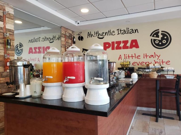 Buffet de desayuno con dispensadores de zumos y zona de pizzas auténtica italiana en Arecibo Inn