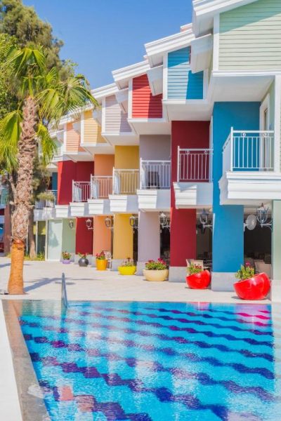 Piscina exterior con coloridas fachadas y balcones del Crystal Club World of Colours Comfort Collection