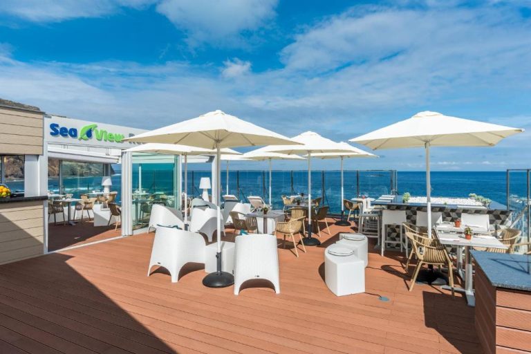 Terraza exterior del restaurante Sea View en Aqua Natura Madeira con mesas y vistas al océano