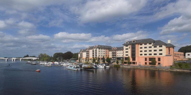 Vista panorámica del Radisson Blu Hotel Athlone junto al río Shannon con embarcaciones en el puerto deportivo