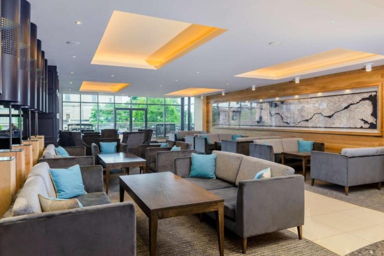 Zona lounge del lobby con sofás grises y cojines turquesa en el Radisson Blu Hotel Athlone