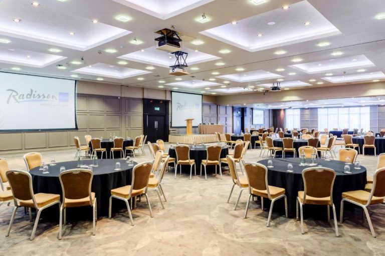 Amplio salón de conferencias con mesas redondas y pantallas de proyección en Radisson Blu Hotel Athlone
