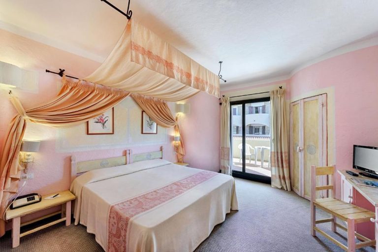 Habitación doble con cama de dosel y balcón en el Grand Hotel Smeraldo Beach