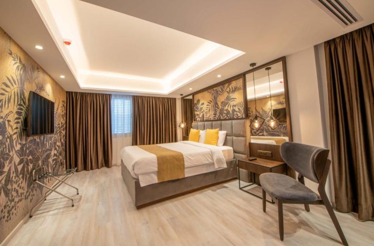 Habitación deluxe con cama doble y decoración tropical dorada en Almond Business Hotel