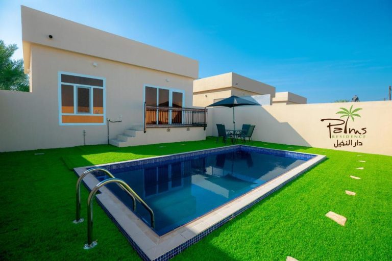 Piscina privada con jardín de césped verde en Palms Residence Inn دار النخيل