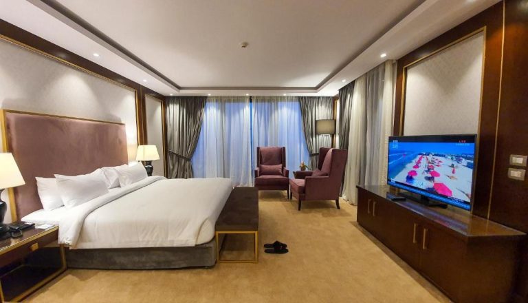 Habitación deluxe con cama king size y televisión en el Porto Said Hotel & Spa de Egipto