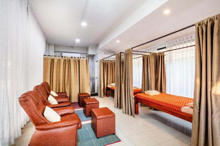 Sala de spa con camillas de masaje y sillones reclinables de cuero en Livotel Hotel Hua Mak Bangkok