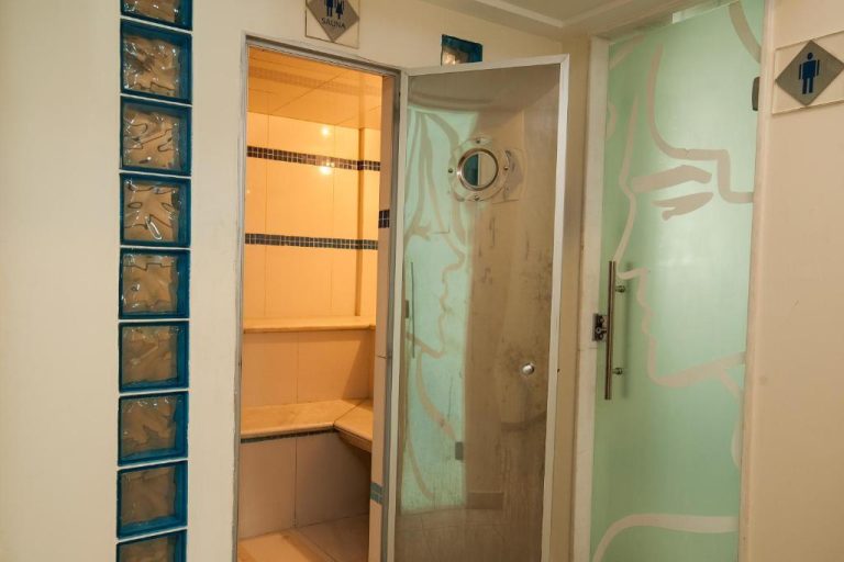 Sauna y vestuario masculino con puerta de cristal en el spa del Hotel Astoria Palace